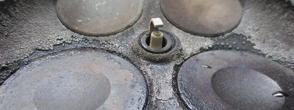 Carbon deposits across the faces of a four-valve combustion chamber.